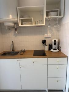 a kitchen with white cabinets and a sink at La parenthèse - 50 m de la plage in Saint-Hilaire-de-Riez +9 photos