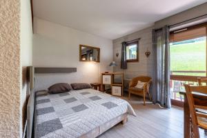 a bedroom with a bed and a desk and a window at Studio 9 - La Palettaz in Crest-Voland