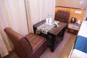 Habitación con mesa, sofá y silla en Drift Wood Homestay, en Kūfrī