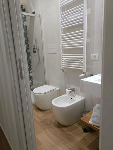a white bathroom with a toilet and a sink at PIANESE house 1 in Campobasso
