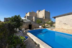 a swimming pool in front of a castle at Masseria Antoglia Exclusive Villa in Villa Castelli