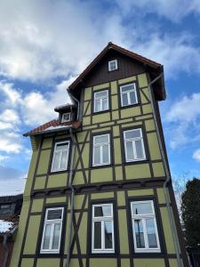 a green and yellow building with white windows at Haus HarzZauber - Elegantes Ferienquartier in der Altstadt mit Terrasse, Kamin und E-Bikes für die perfekte Auszeit in Wernigerode