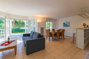 a living room with a couch and a table at Résidence Lagrange Vacances Villas Eden Club in Lacanau-Océan