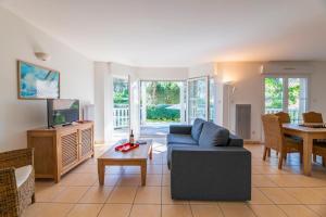 a living room with a couch and a table at Résidence Lagrange Vacances Villas Eden Club in Lacanau-Océan