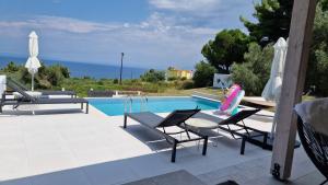 a patio with a table and chairs next to a swimming pool at Anna Maria Mini Villa in Kriopigi
