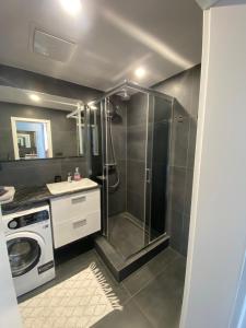 a bathroom with a shower and a washing machine at City Flat - Garage parking - TRITA SK in Poprad +20 photos