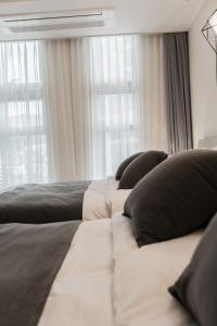 - une chambre avec 2 lits avec des oreillers et une fenêtre dans l'établissement Seoul Station Sky Lounge House, à Séoul 49 autres photos