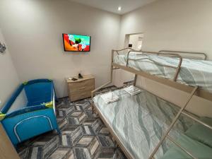 a room with two bunk beds and a tv at Teo's house in Asprovalta