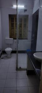 a bathroom with a shower and a toilet and a sink at YWCA GALLWAY GUEST HOUSE in Kolkata