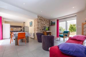 CrachにあるLa clé du bonheurのテーブルと椅子のあるキッチンとリビングルーム