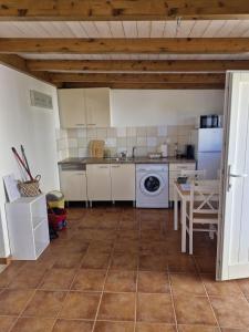 a kitchen with a table and a white appliance at Casa Amarela in Zambujeira do Mar +22 photos