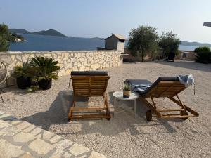 two chairs and a table in front of the water at Adriatic Dream - Mobile Home - Oaza Mira in Drage