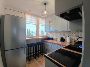 a kitchen with a stainless steel refrigerator and cabinets at Apartament Kotlina in Kłodzko