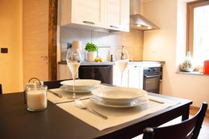 a kitchen with a table with two plates and wine glasses at La Casa nel Nebbiolo in Pont-Saint-Martin
