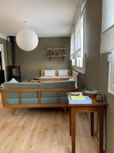 a living room with a bed and a table at Maison plages & centre à pieds - proche GR34 in Saint-Pol-de-Léon