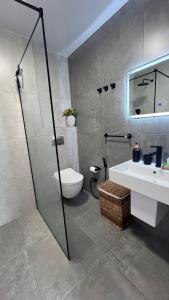 a bathroom with a shower and a toilet and a sink at Апартаменты с шикарным видом на море in Batumi