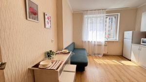 a living room with a table and a blue couch at EmmaApart Comfort 169 in Astana