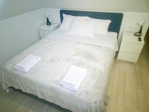 杜布罗夫尼克Marich Homestay的卧室里有一张白色的大床，床上放着毛巾
