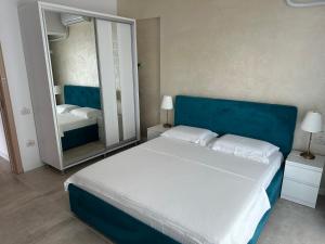 ein Schlafzimmer mit einem blauen Bett und einem Spiegel in der Unterkunft Zev-S10 in Mamaia Nord – Năvodari