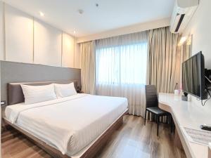 a bedroom with a bed and a desk and a television at Citin Sukhumvit 11 Nana Bangkok by Compass Hospitality in Bangkok