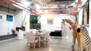 una sala da pranzo con un tavolo, giraffe e sedie di 瀚寓夏天 Hanns Summer a Taipei