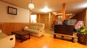 a living room with a couch and a table at Minshuku Asogen in Aso