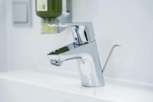 un robinet de salle de bain argenté sur un lavabo blanc dans l'établissement Lifestyle Apartments, à Villingen-Schwenningen 31 autres photos