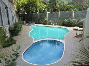 ein großer blauer Pool mit einem Backsteingang um ihn herum in der Unterkunft Apple One Banawa Heights in Cebu City + 5 Fotos