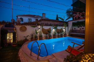 a swimming pool with two chairs next to a house at The Comelly Alaçatı in Çeşme