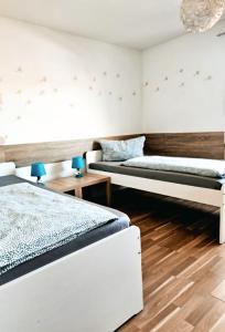 Dos camas en una habitación con suelo de madera. en Ferienwohnung Leon, en Sinsheim 16 fotos más