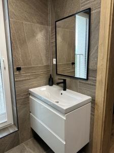 a bathroom with a white sink and a mirror at Apartment lilly in Poprad +14 photos