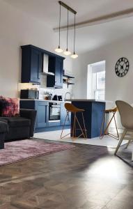 a living room with blue cabinets and a kitchen at 1A Cathedral Place - Cathedral Townhouses Cobh in Cobh