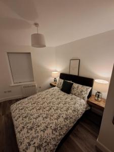 a bedroom with a bed and two lamps at 1A Cathedral Place - Cathedral Townhouses Cobh in Cobh