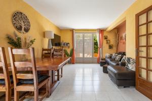 un soggiorno con un tavolo e un divano di La Maison Ensoleillée - Avec jardin et terrasse ad Agde