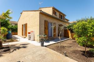 una piccola casa con un albero di fronte di La Maison Ensoleillée - Avec jardin et terrasse ad Agde