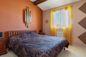 una camera da letto con un letto e una finestra di La Maison Ensoleillée - Avec jardin et terrasse ad Agde