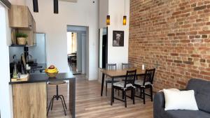 a kitchen and dining room with a brick wall at Zapisane w Cegle by LibertaRent in Świdnica
