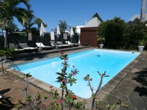 - une piscine avec des chaises dans un complexe dans l'établissement Villa Belle, à Saint-Pierre