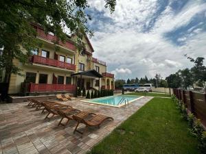 a house with a swimming pool and some benches at Palic Memories by Vermes - Lake View in Palić