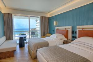 ein Hotelzimmer mit zwei Betten und Blick auf das Meer in der Unterkunft Mövenpick Hotel Beirut in Beirut + 37 Fotos