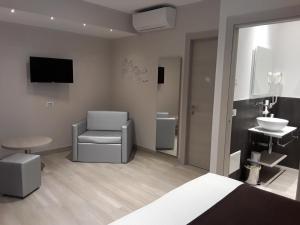 sypialnia z łóżkiem, krzesłem i umywalką w obiekcie Hotel Danieli La Castellana lago di Garda w Brenzone sul Garda