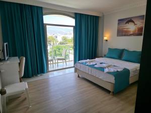 Un dormitorio con una cama y una ventana grande. en Forum Residence Hotel, en Marmaris 109 fotos más