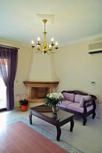 a living room with a purple couch and a chandelier at Kerveli Luxury Villa in Kerveli