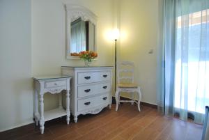 a white dresser with a mirror and a chair in a room at Kerveli Luxury Villa in Kerveli
