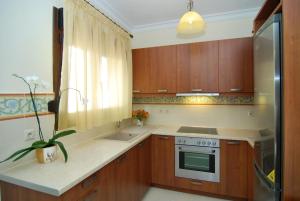 a kitchen with wooden cabinets and a stove top oven at Kerveli Luxury Villa in Kerveli