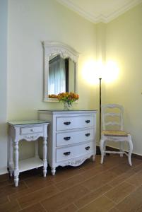 a bedroom with a dresser and a chair and a mirror at Kerveli Luxury Villa in Kerveli