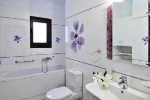 a white bathroom with a toilet and a sink at Kerveli Luxury Villa in Kerveli
