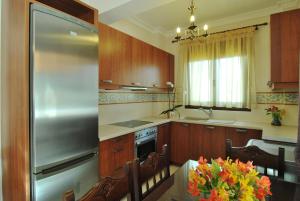 a kitchen with a stainless steel refrigerator and a table at Kerveli Luxury Villa in Kerveli