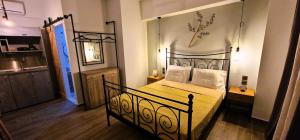 a bedroom with a black bed with yellow sheets and white pillows at My Afytos Garden in Afitos