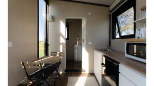 a kitchen with a table and two chairs and a microwave at River Road Retreat 1 by Tiny Away in Southburn